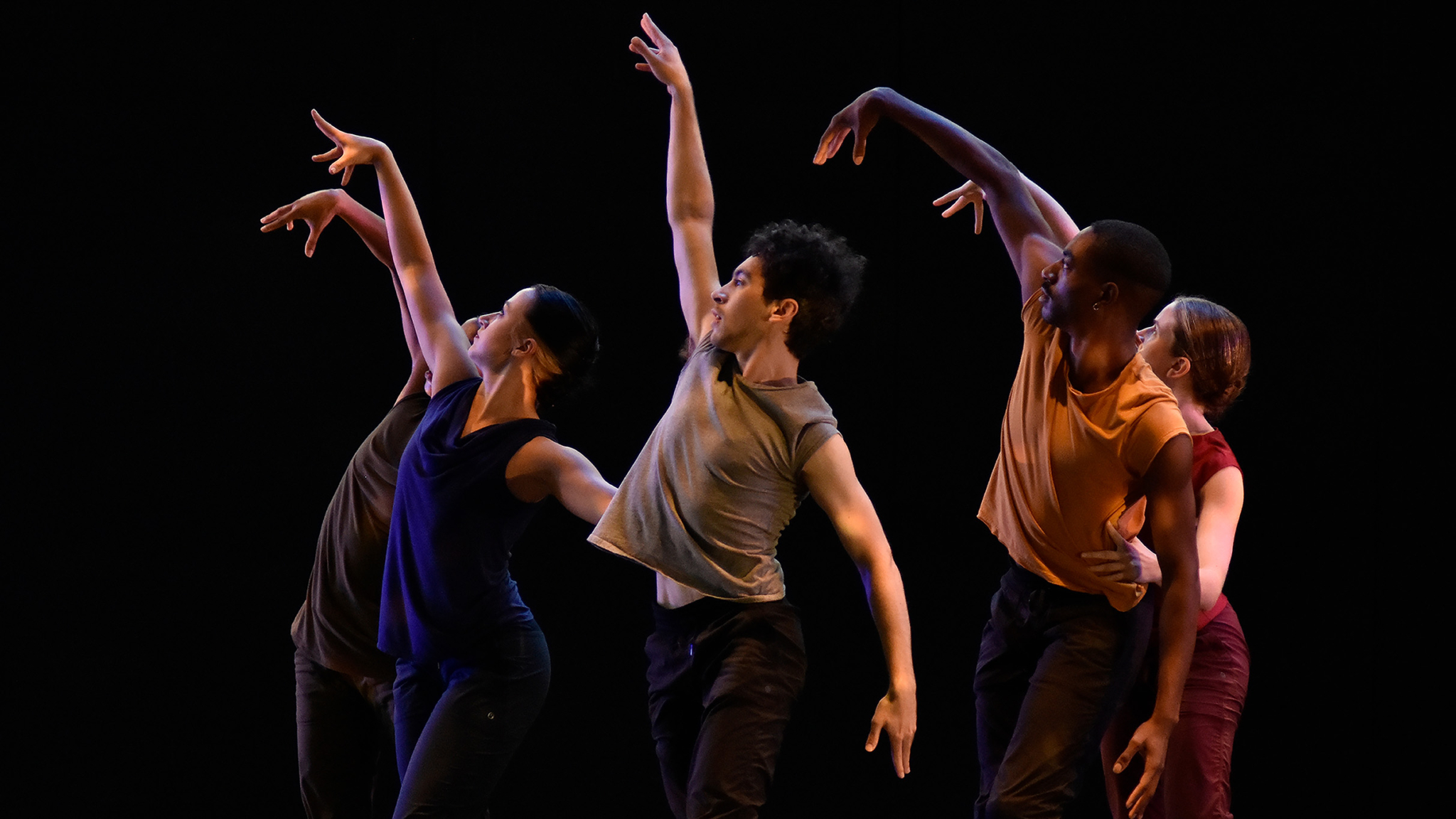 GroundWorks Company Dancers in a clump all with their right arm lifted above their heads.